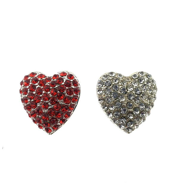 Two heart-shaped diamante buttons with shank, one with red crystals and one with clear crystals, against a white background.