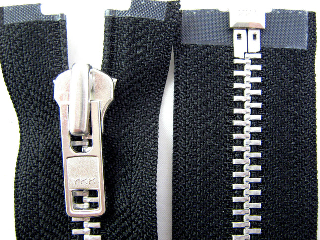 Close-up of a heavy-duty metal open-end zip by YKK, showing the teeth and slider against a black background. 