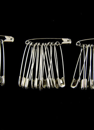 Three packs of extra large safety pins made of steel, with each pack containing 36 pins arranged in parallel against a black background.
