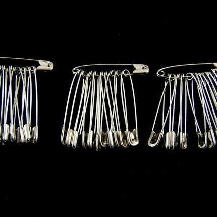Three packs of extra large safety pins made of steel, with each pack containing 36 pins arranged in parallel against a black background.