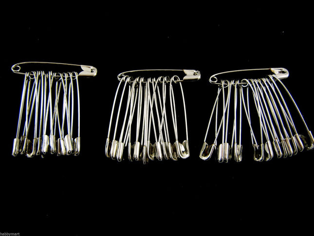 Three packs of extra large safety pins made of steel, with each pack containing 36 pins arranged in parallel against a black background.