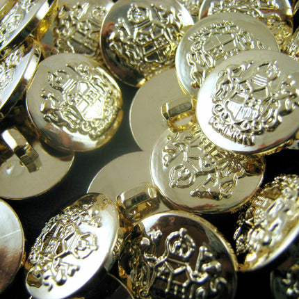 A collection of gold plastic crested blazer buttons with shank attachments.