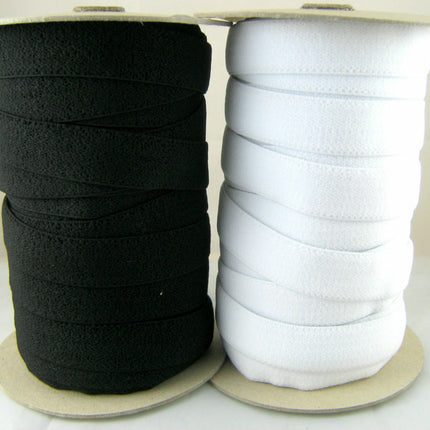 Rolls of plush back elastic in black and white, showing the soft velvety side intended for skin contact.