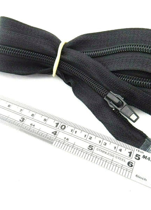 An extra long sleeping bag zip placed next to a ruler, showing its length.
