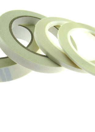 Reels of double-sided sticky tape laid out on a surface.