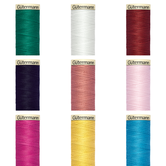 A collection of Gutermann Sew All sewing thread in various colors, displayed in individual spools.