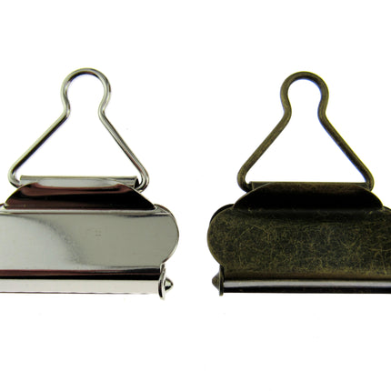 Silver and antique brass colour dungaree clasps set on a white background