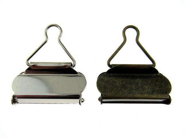 Silver and antique brass colour dungaree clasps set on a white background