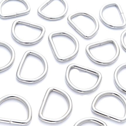 A collection of silver nickel-plated solid welded D rings in various sizes arranged on a white background.