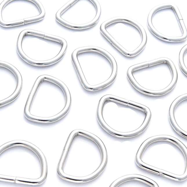 A collection of silver nickel-plated solid welded D rings in various sizes arranged on a white background.