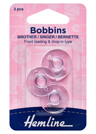 Package of three plastic bobbins compatible with Brother, Singer, and Bernette sewing machines, displayed in clear packaging with pink and blue branding.