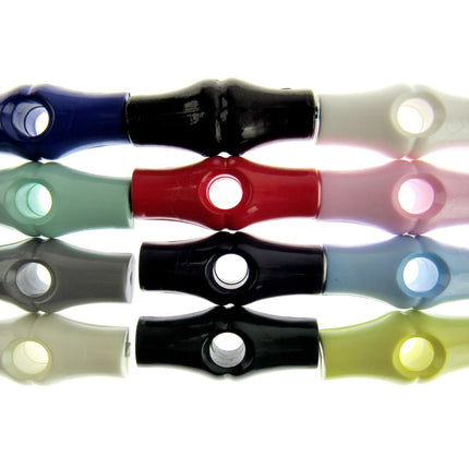 An assortment of bamboo shaped plastic toggle buttons in various solid colors.