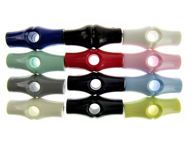 An assortment of bamboo shaped plastic toggle buttons in various solid colors.