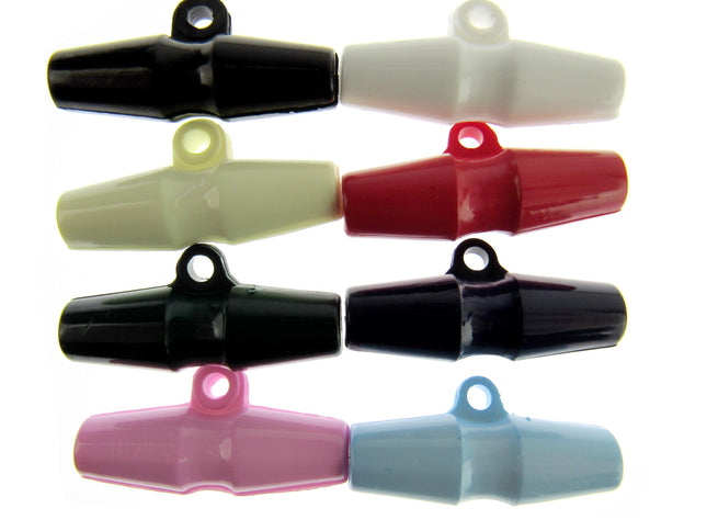 An array of barrel-shaped duffle coat toggle buttons in various solid colors including black, white, red, yellow, pink, and blue.