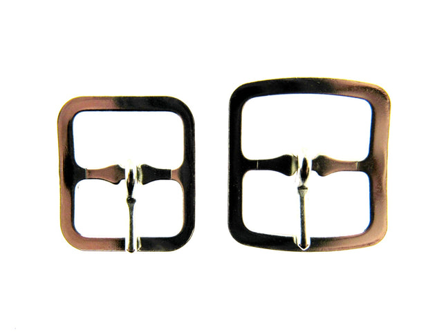 A pair of silver coloured shoe or kilt buckles on a white background