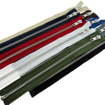 A collection of YKK metal open end zips in various colors including black, white, beige, grey, olive, red, and navy, arranged side by side.