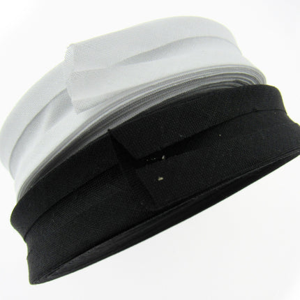 A roll of bias binding tape, partially unrolled, showing both black and white strands.