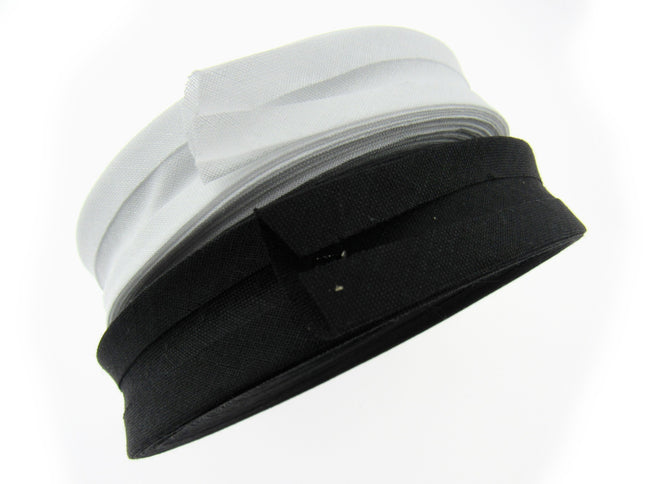 A roll of bias binding tape, partially unrolled, showing both black and white strands.