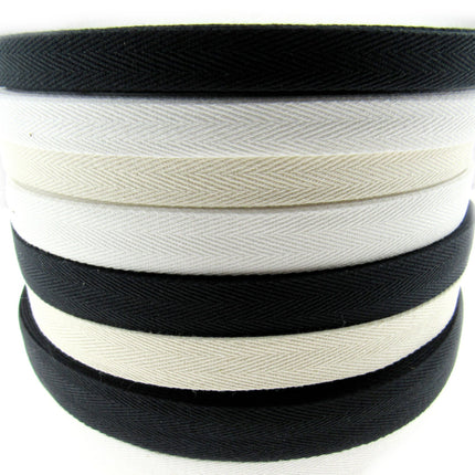 Rolls of cotton twill apron webbing tape in black, white, and beige colours