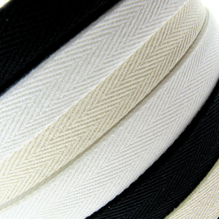 Rolls of cotton twill apron webbing tape in black, white, and beige colours