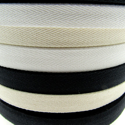 Rolls of cotton twill apron webbing tape in black, white, and beige colours