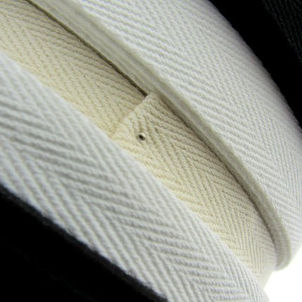 Rolls of cotton twill apron webbing tape in black, white, and beige colours