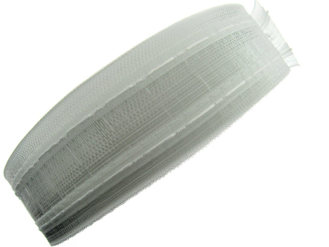 A translucent net pleat curtain tape rolled up.
