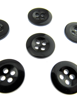 Six four hole black trouser buttons on a white background