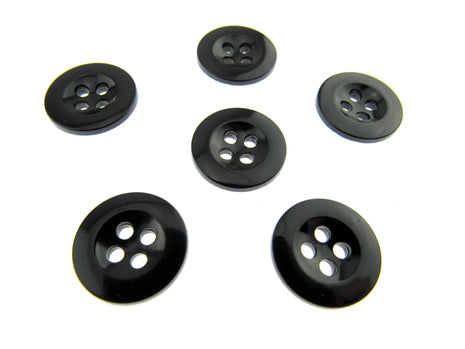 Six four hole black trouser buttons on a white background