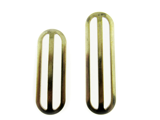 Two gold metal sliders with a rectangular shape, used for adjusting webbing strap length.