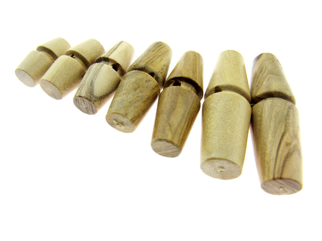 A collection of wooden toggles made from olive wood, displayed in a row with different sizes.