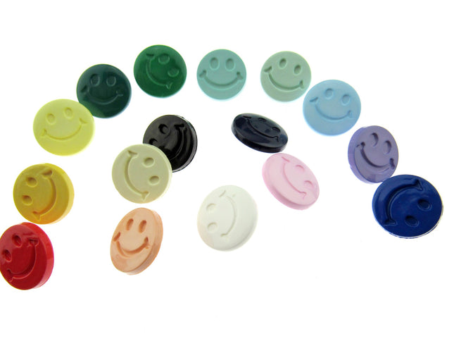 Smiley face buttons in an array of colours on a white background