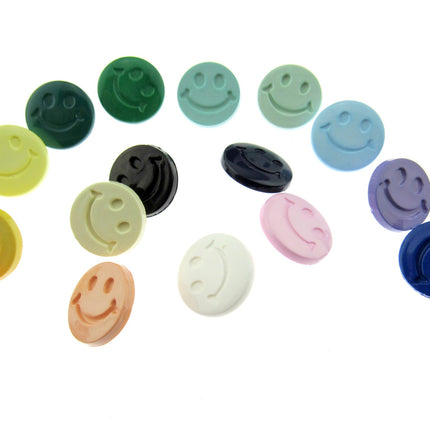 An array of smiley plastic shank buttons in multiple colours on a white background