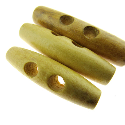 Three wooden coat toggles with two drilled holes each, displayed against a white background.
