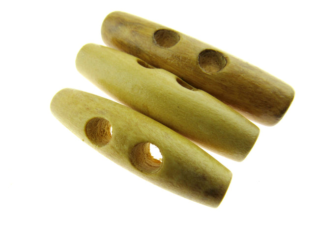 Three wooden coat toggles with two drilled holes each, displayed against a white background.