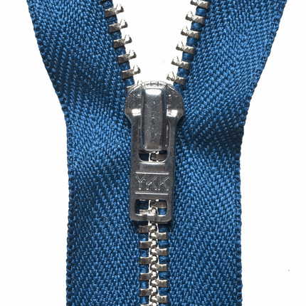 Close up view of heavy duty YKK metal trouser zips showing the brass teeth and autolock slider.